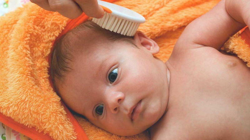 Chải tóc cho trẻ sơ sinh quá nhiều có thể gây tổn thương nang tóc và da đầu của bé